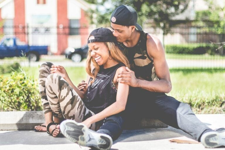 couple sitting together on a sidewalk